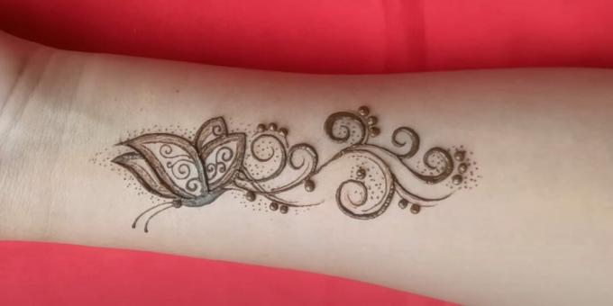 Henna sommerfugltegning på hånden: dekorere tatoveringen med prikker
