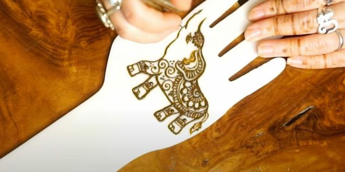 Henna tegning av en elefant på hånden: legg et mønster til øret og magen