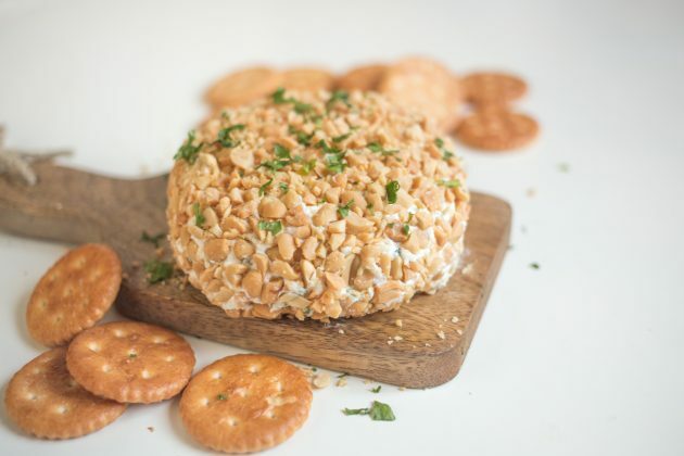 Dypp en ostekule i peanøtter og server en matbit