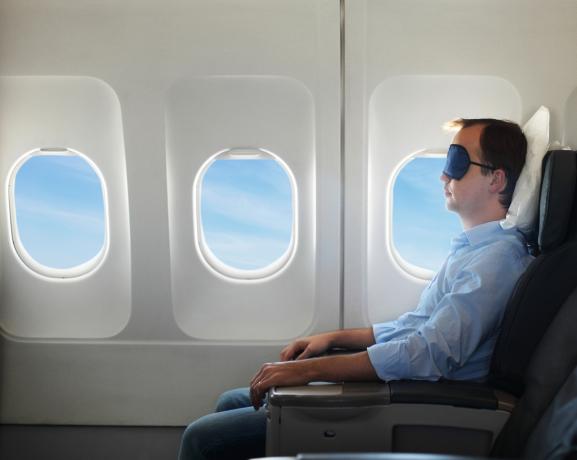 Portrett av mann slapper av i flyet